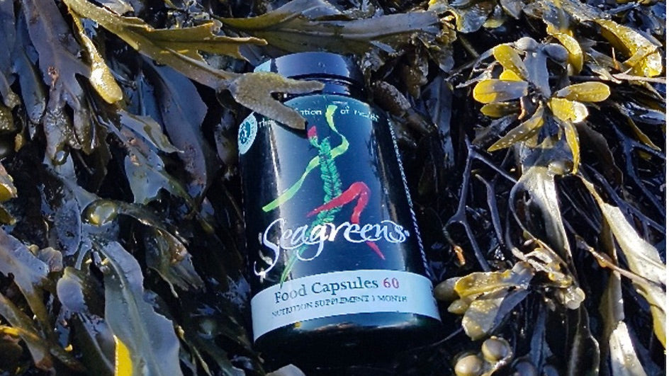 Supplement bottle labeled 'Seagreens' on a bed of seaweed