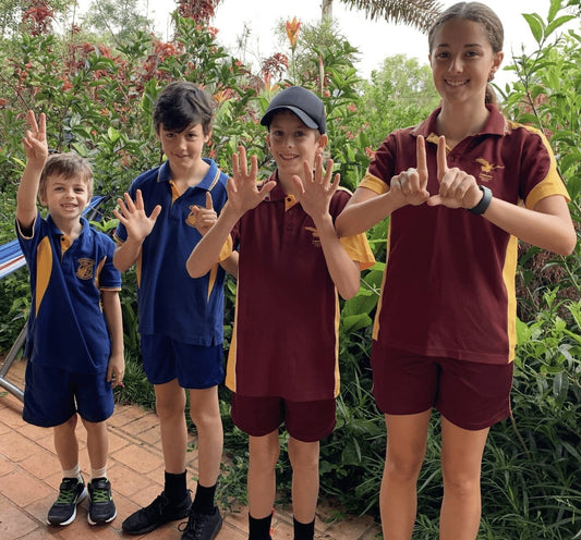 Four children of different ages in school uniform.