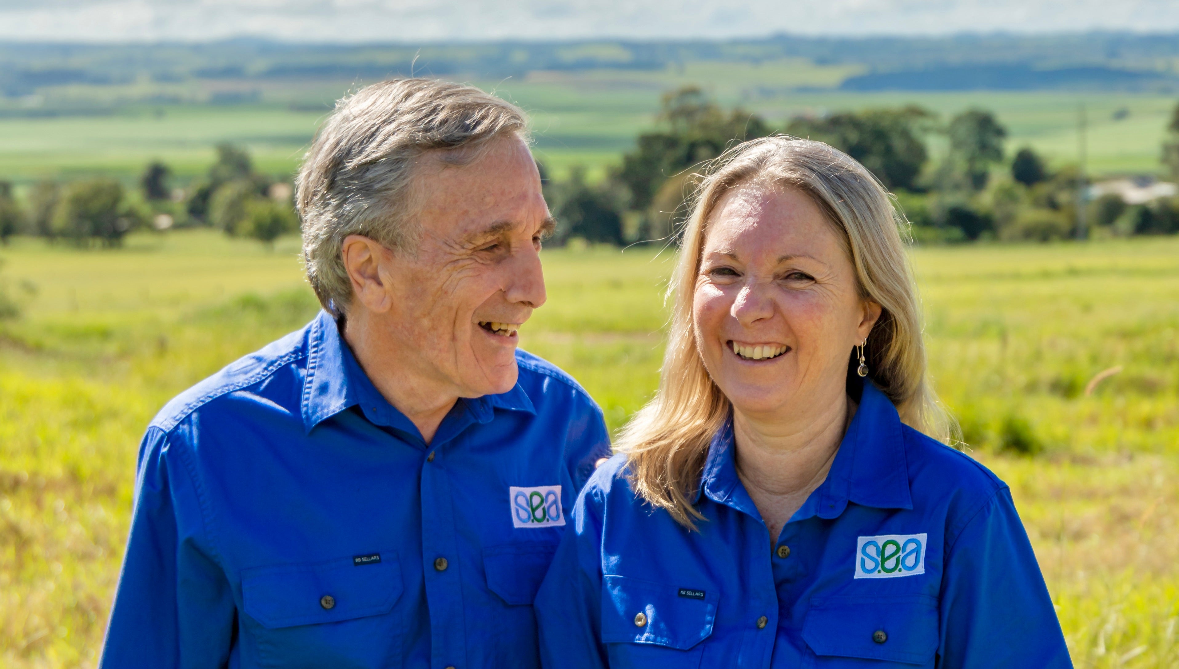 Grahame and Liz standing with Grahame looking at Liz and laughing
