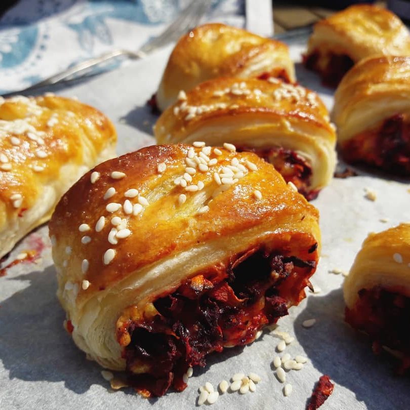 Pastry rolls with sesame seeds on a paper surface