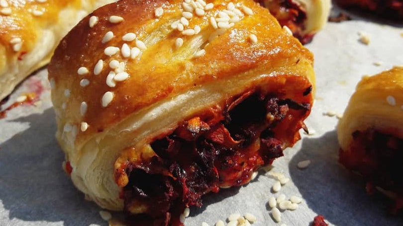 Vegan seaweed pastry rolls with sesame seeds on a paper surface